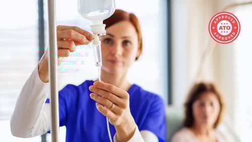 Healthcare professional adjusting IV drip in hospital setting, ATO approved