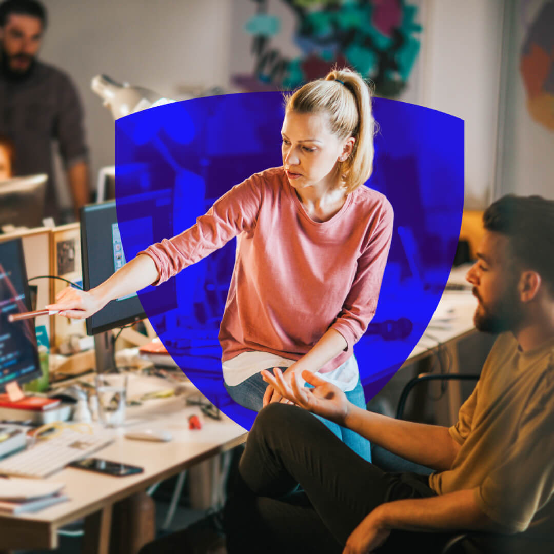 Woman in pink sweater collaborating with male colleague at computer workstation in modern office environment Woman in pink sweater collaborating with male colleague at computer workstation in modern office environment